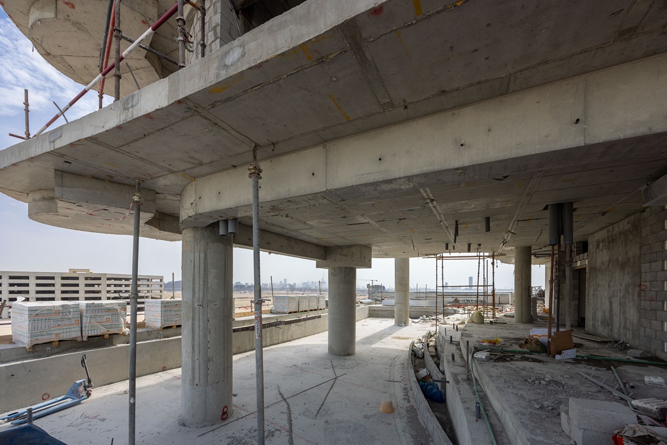 Beach Walk Residence A view of a construction site featuring exposed concrete beams, scaffolding, and unfinished walls.